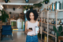Shot of a young woman using a smartphone while shopping in a waste free store